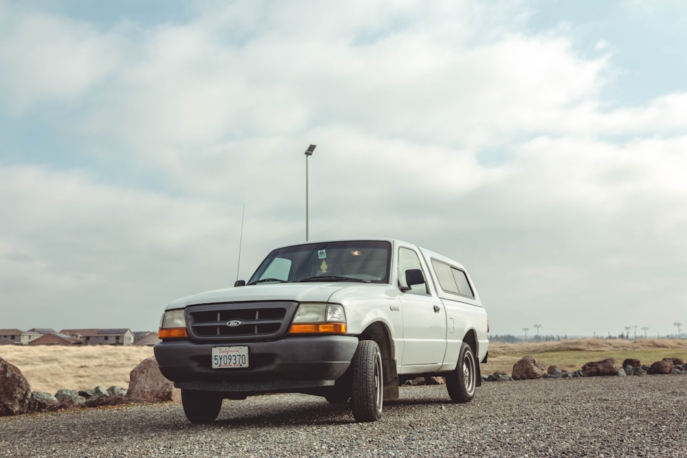 white vehicle parked near rocks and light post