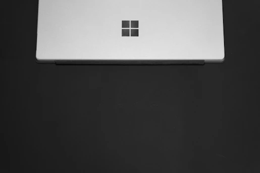 Dark-themed sleek laptop displaying a minimalist website design on screen.