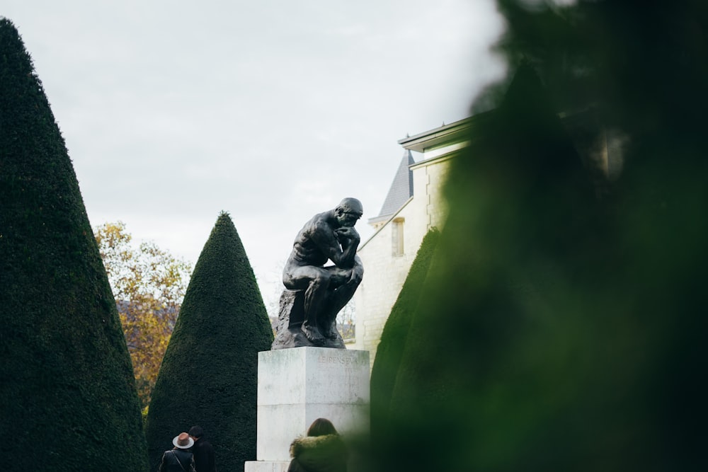 The Thinker statue near trees