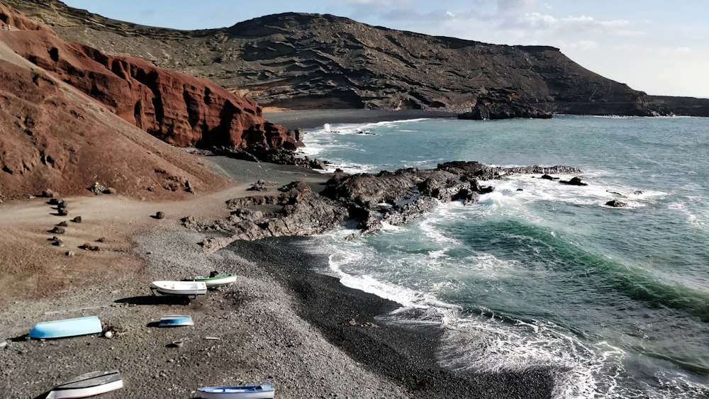 white and blue canoe beside beach