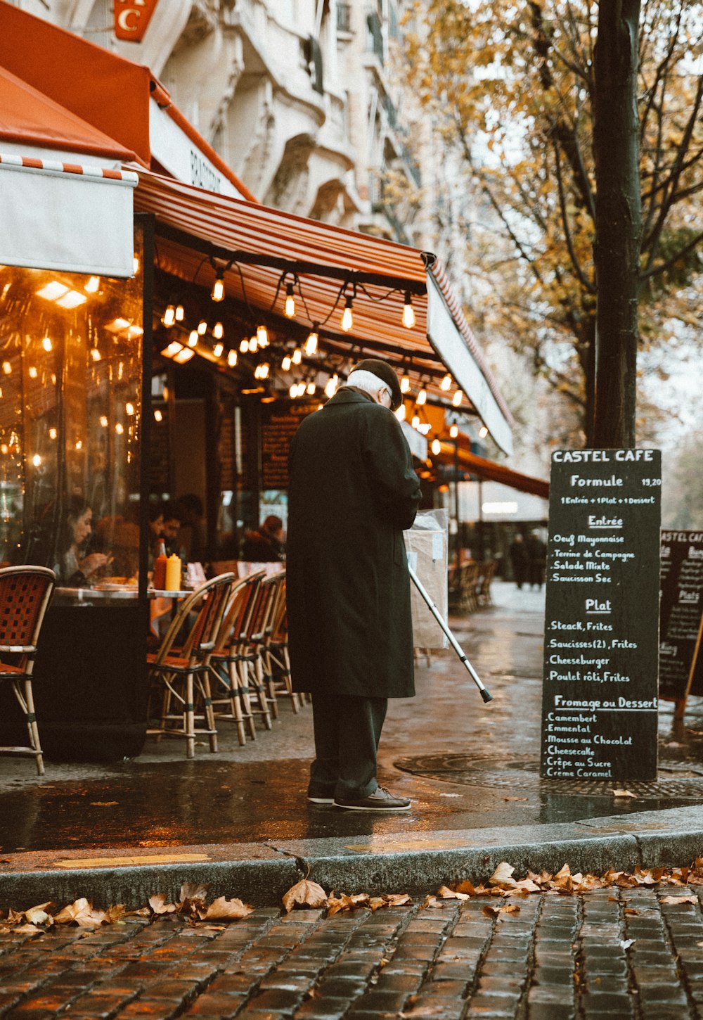 man with walking stick standing near curb