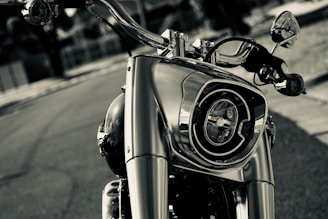 An artistic shot of motorcycle handlebars and mirrors reflecting sunlight.