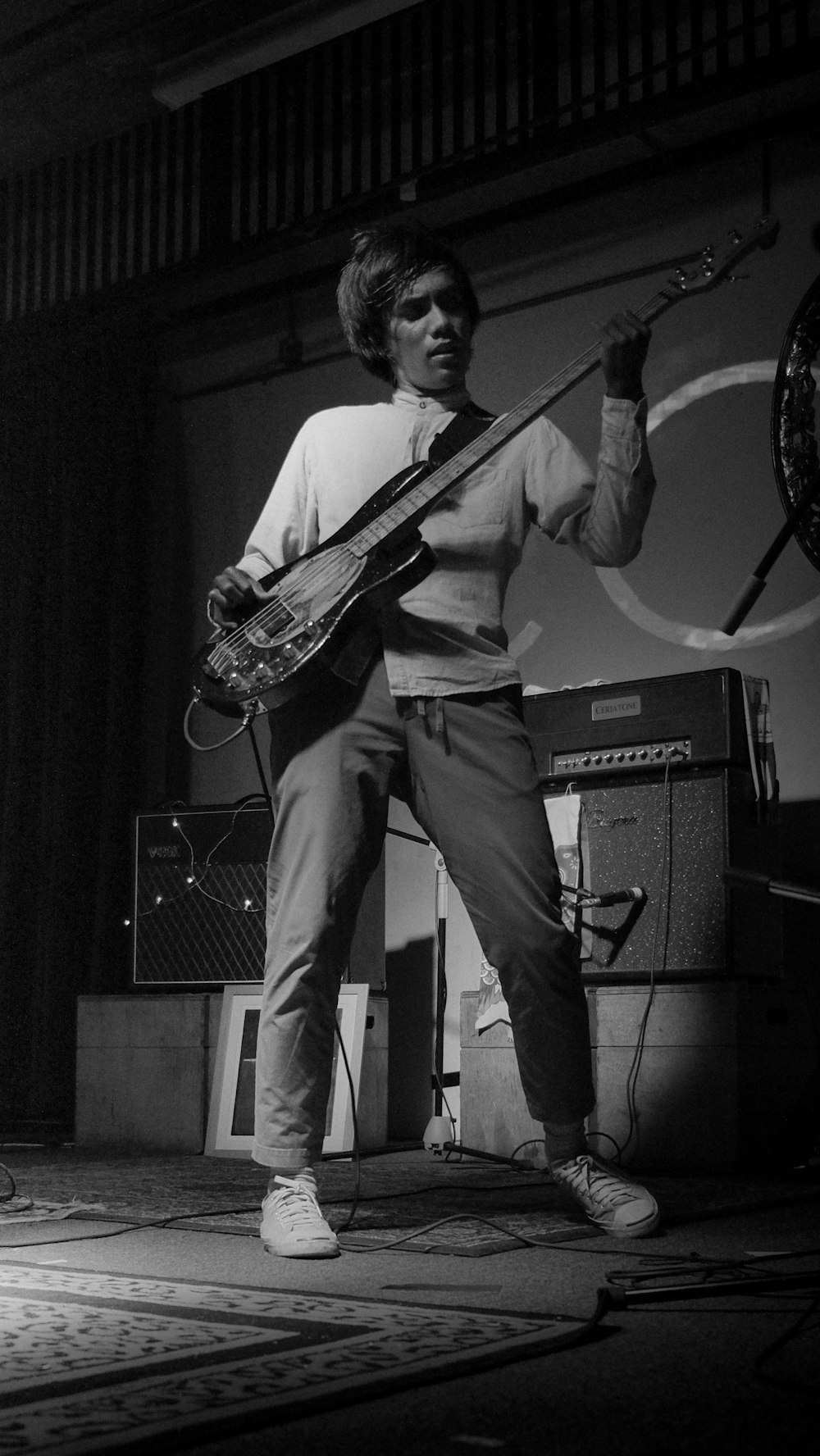 grayscale photography of man playing guitar