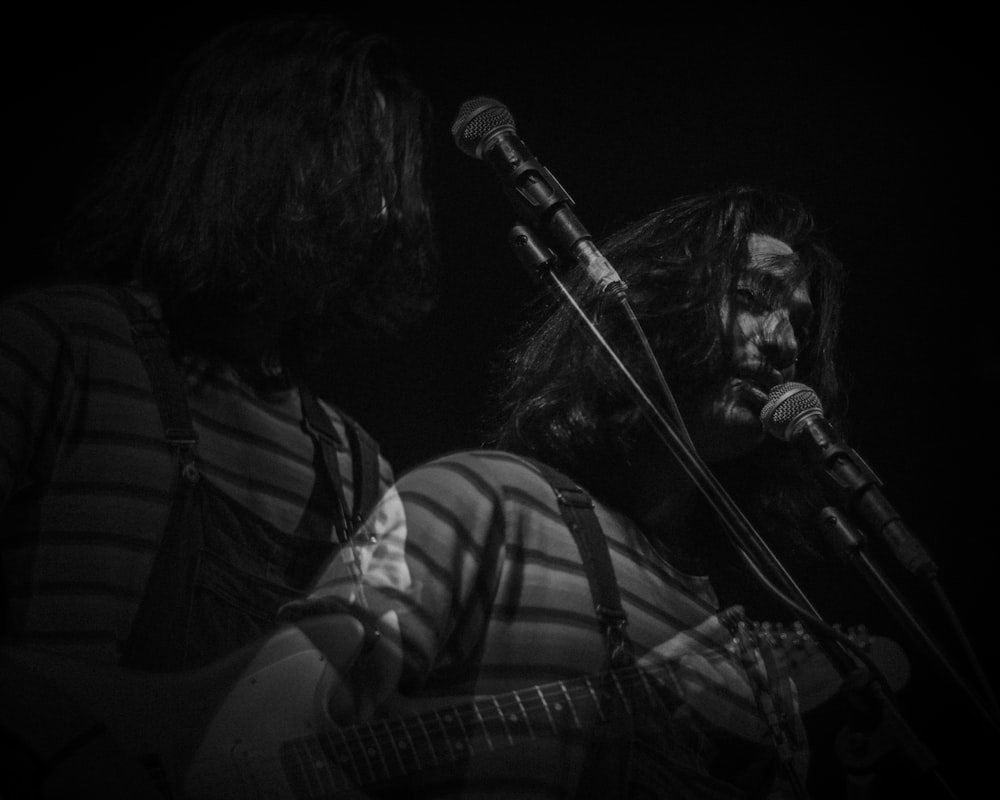 greyscale photo of man singing