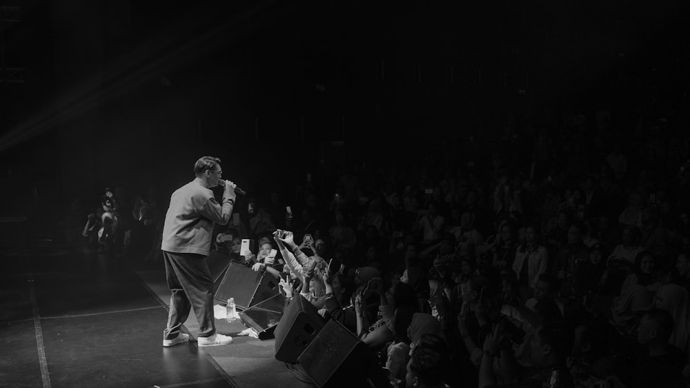 grayscale photo of man holding microphone