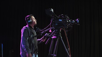 cameraman operating black camera inside room