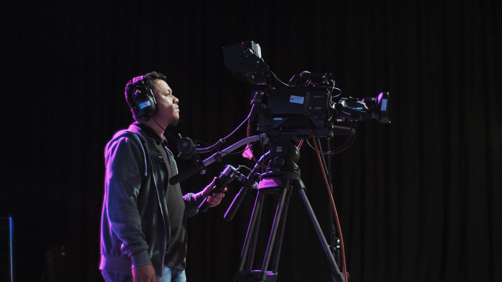 cameraman operating black camera inside room