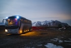 white and black bus running near the mountain