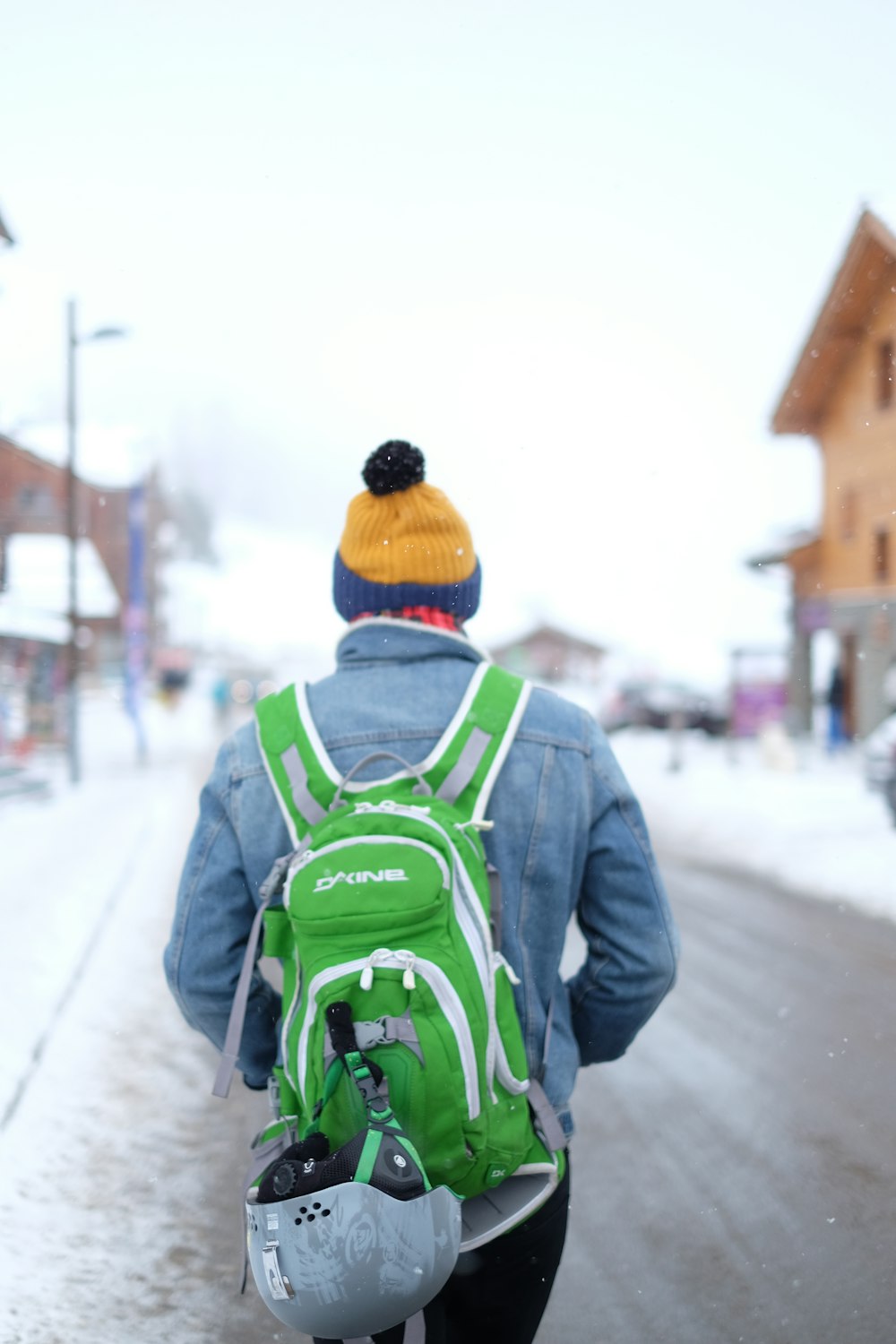 Mann geht mit grün-weißem Rucksack auf der Straße