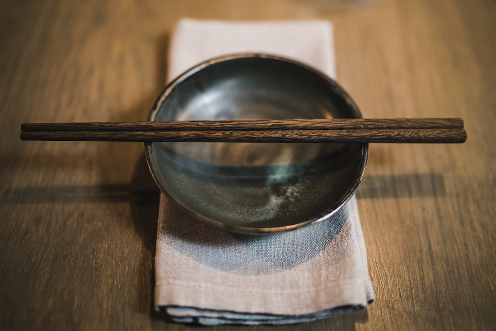 pair of brown chopsticks on round ceramic bowl