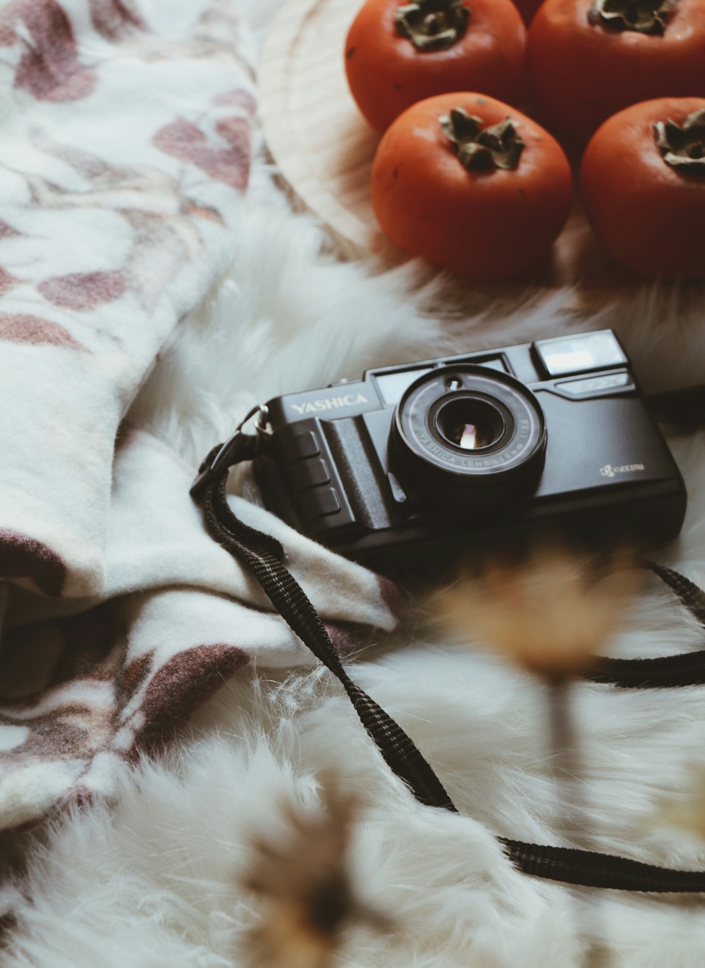 foto con messa a fuoco selettiva della fotocamera Yashica nera su un foglio di pelliccia bianca