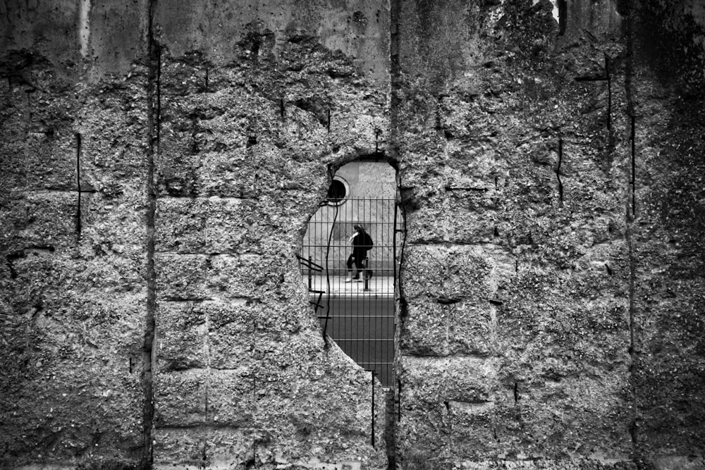 grayscale photography of man inside concrete room