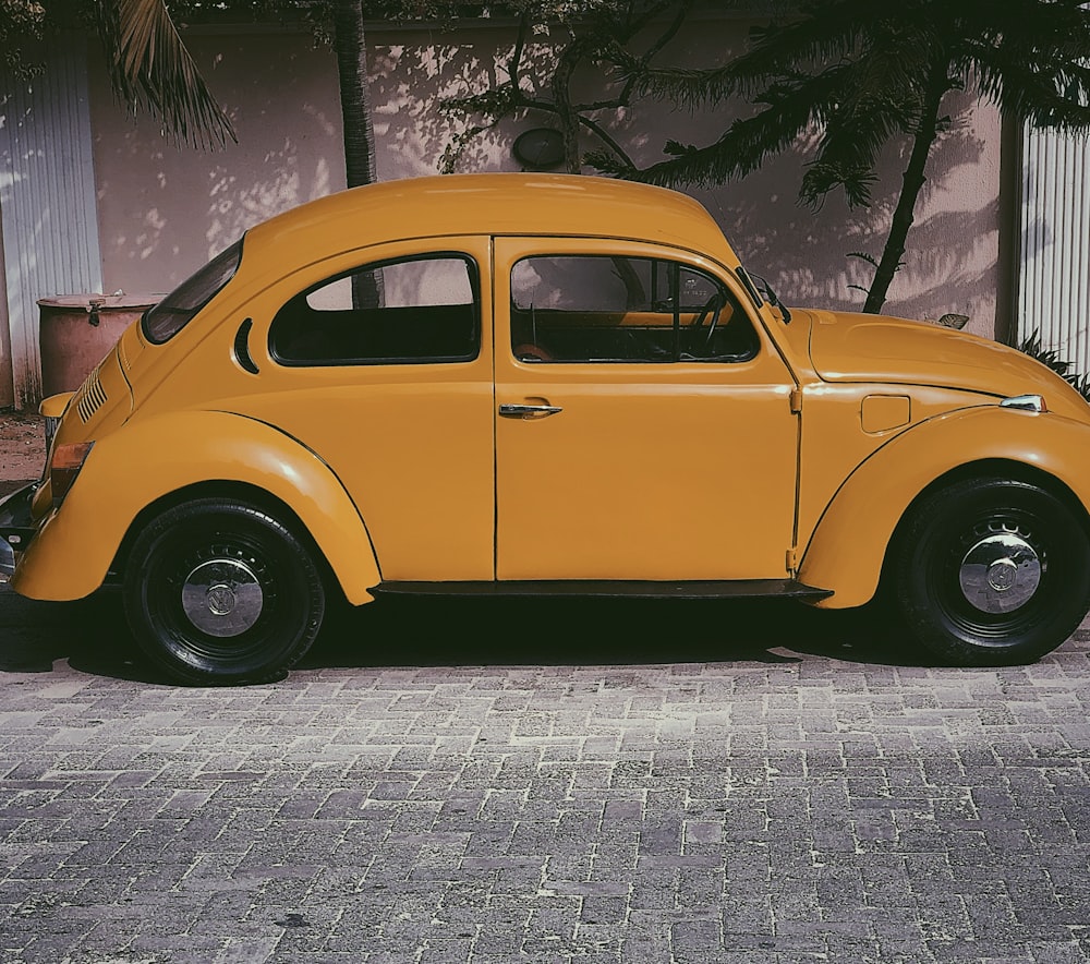yellow Volkswagen Beetle parked