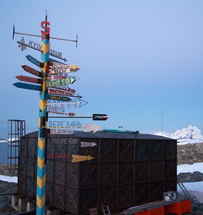 multicolored direction signage beside black shed