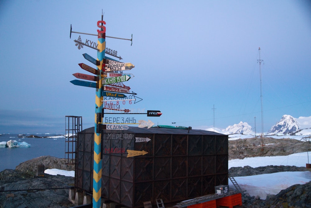 multicolored direction signage beside black shed