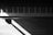 A black and white photo of a piano keyboard with soft natural light highlighting the keys.