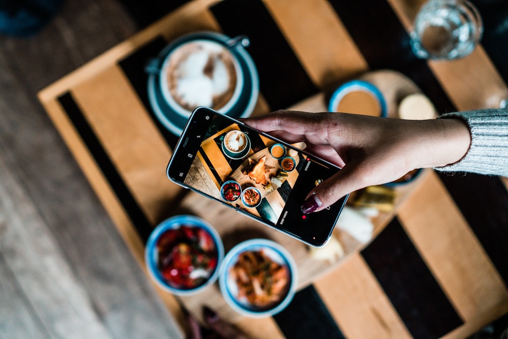 person taking photo to the food