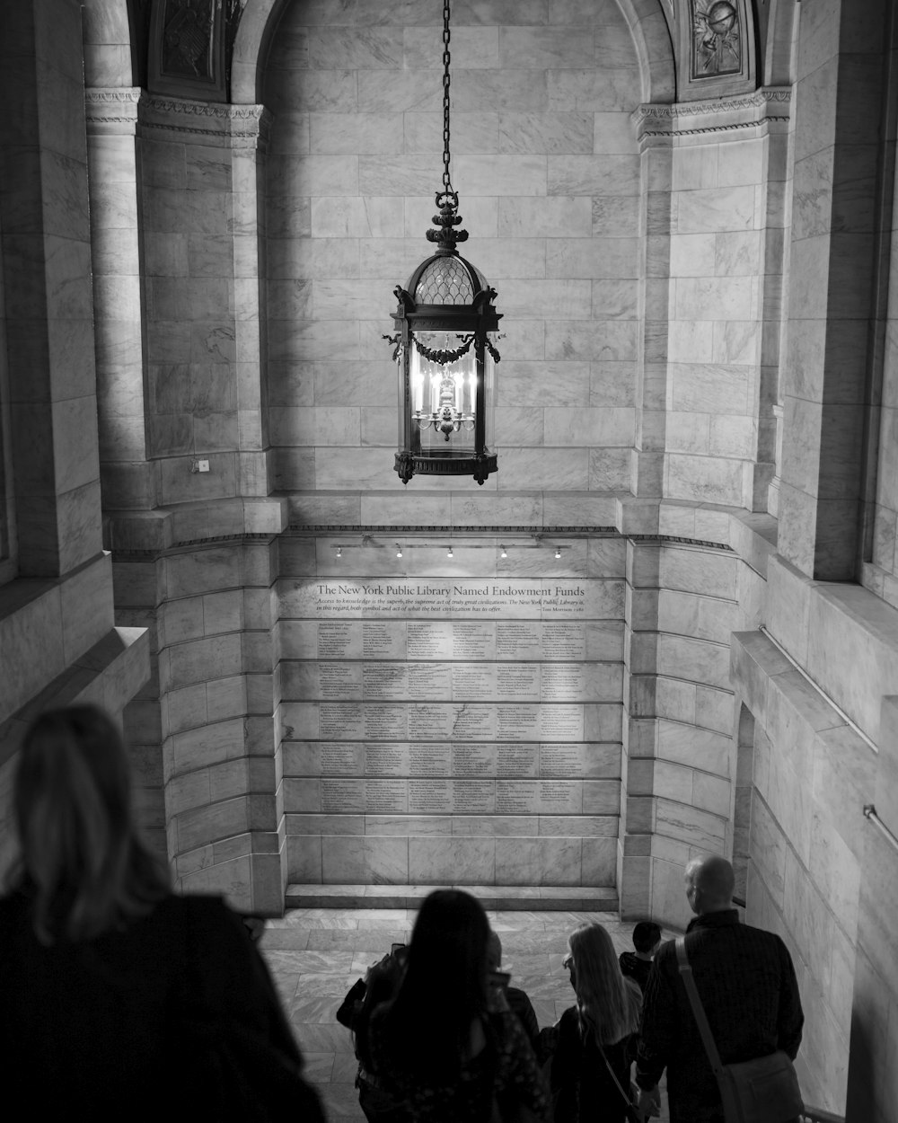 grayscale photography of people walking inside building