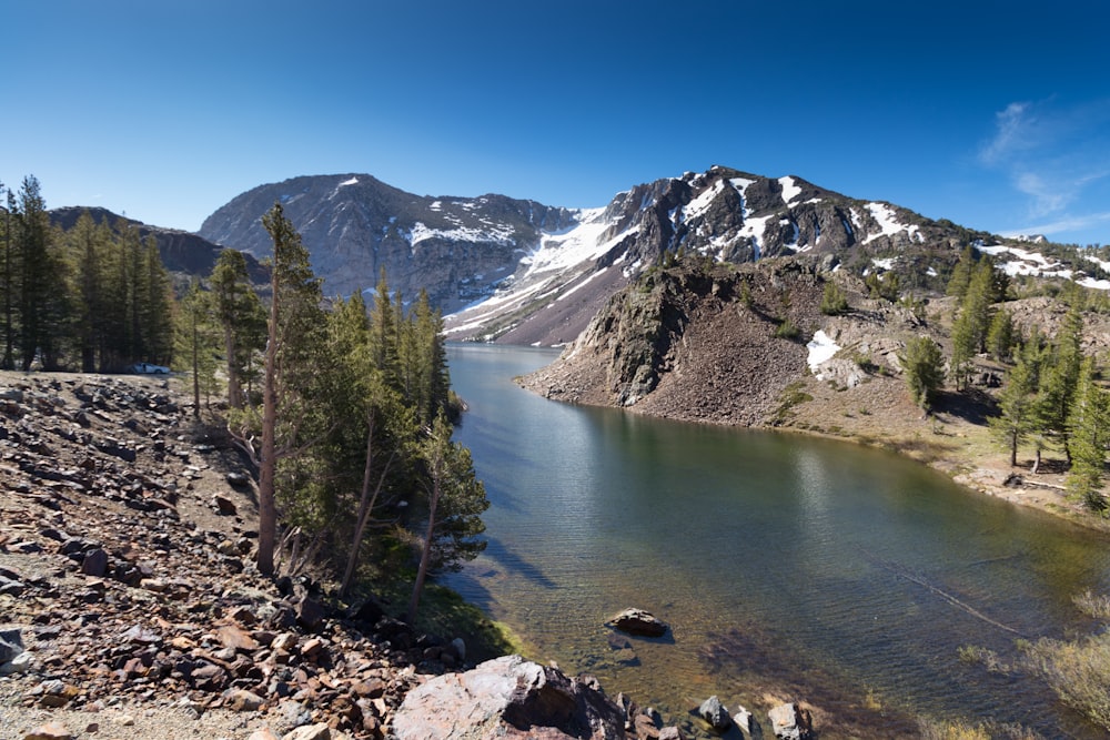 body of water near mountain at daytime