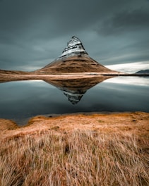 cone mountain with the distance of body of water