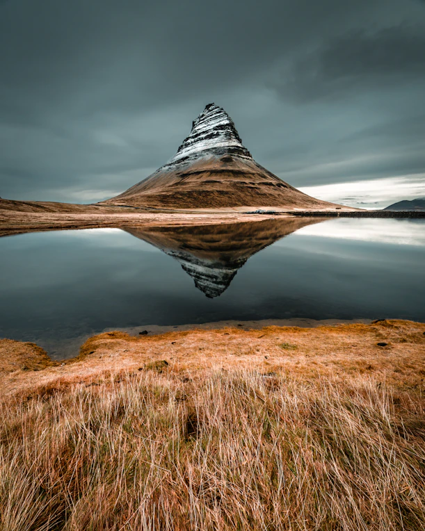 cone mountain with the distance of body of water