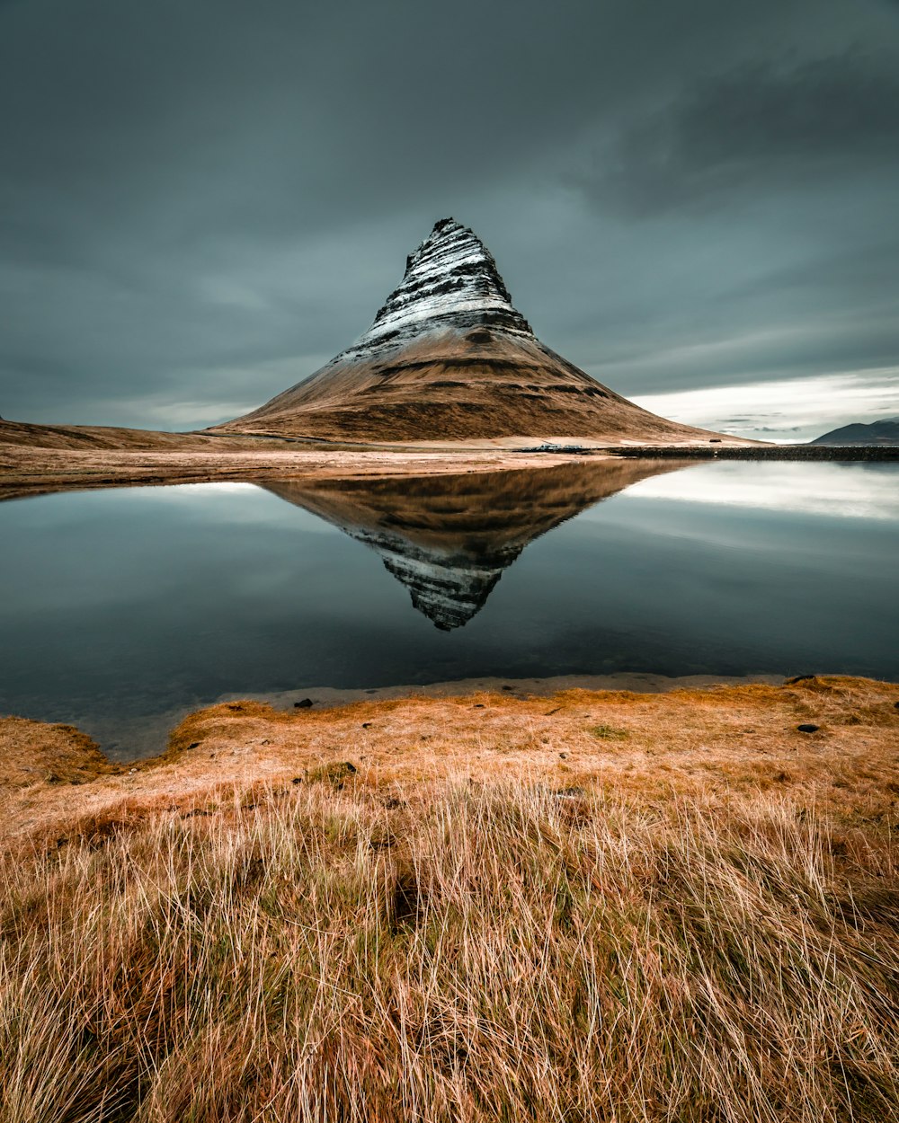 cone mountain with the distance of body of water