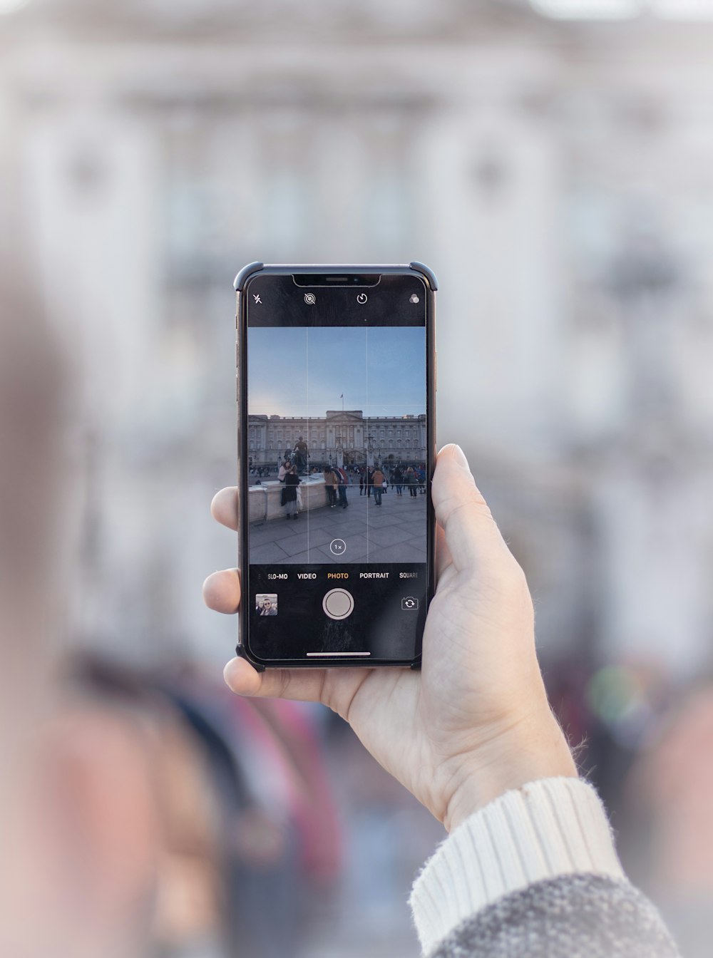 person taking photograph of people near fountain at daytime