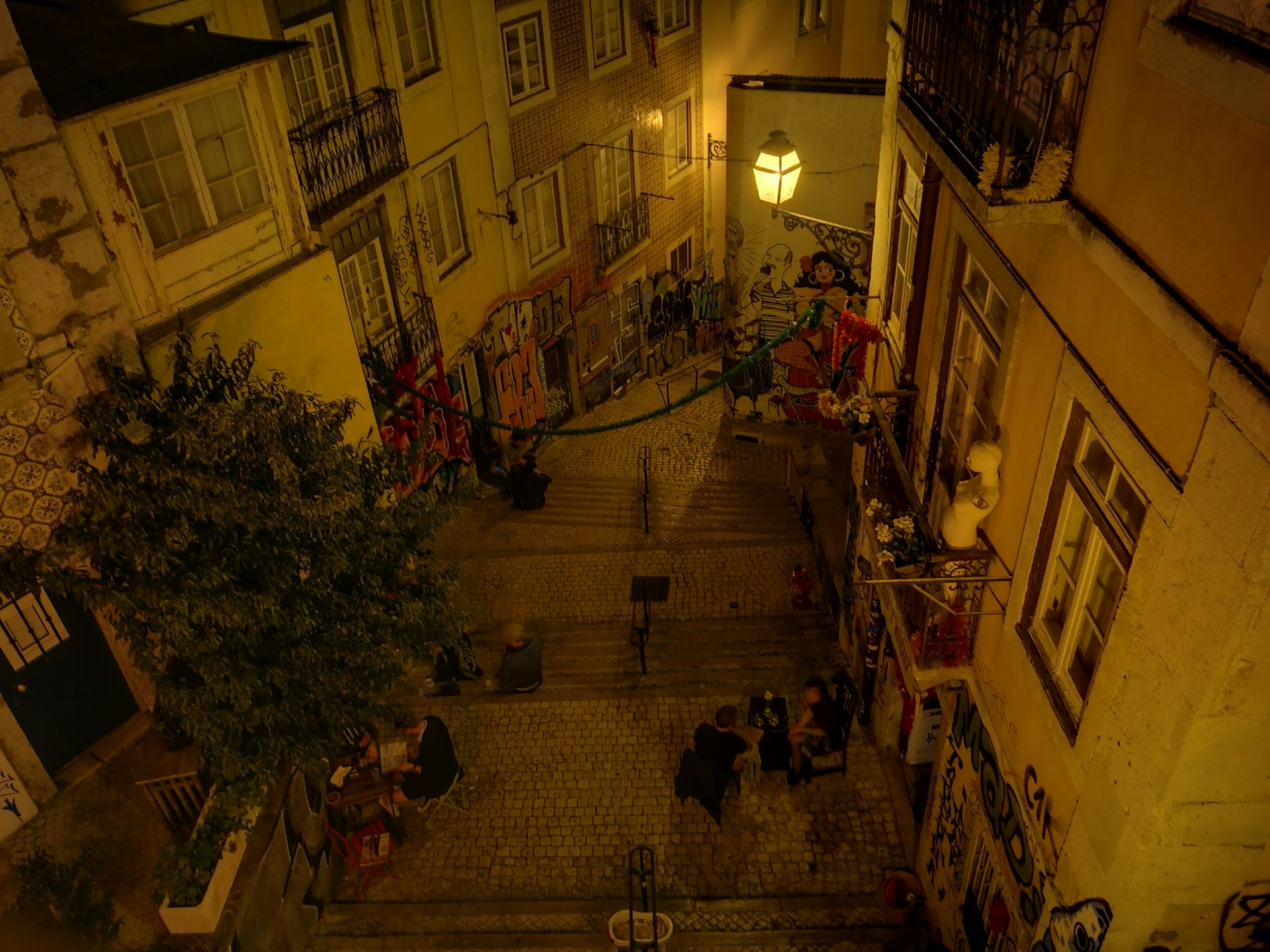 A group of friends eagerly solving clues on a cobblestone street in Hamburg at dusk.