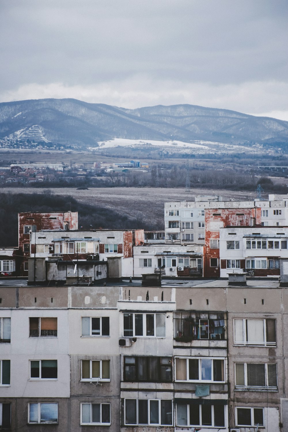 high mountain seen behind grey, white, and brown painted buildings