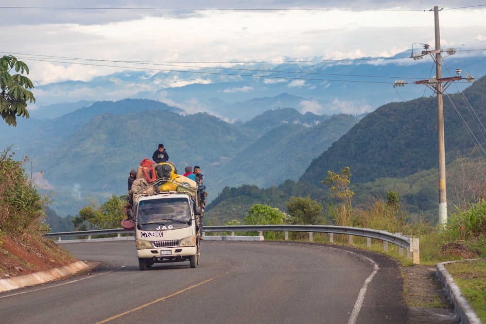 people riding vehicle on road