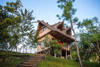 Cozy resort-style wooden house featuring a spacious veranda surrounded by greenery