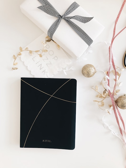Close-up of a minimalist leather gift box with gold foil stamping on a wooden table