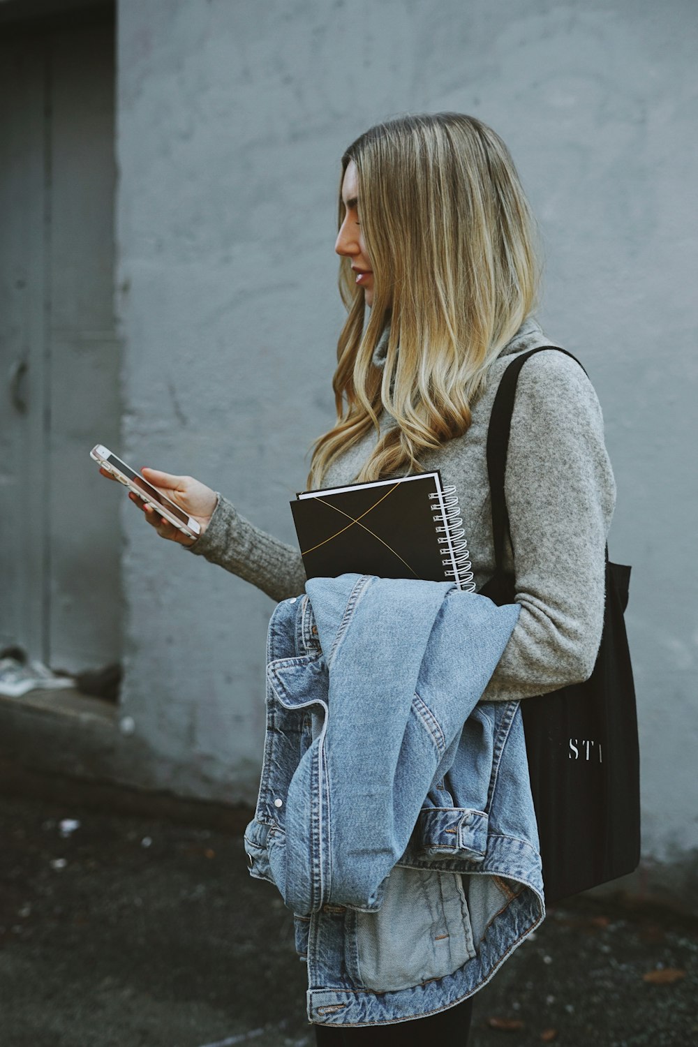 Frau mit Jeansjacke und Telefon