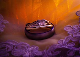 A couple's ring set displayed on a delicate lace cloth with soft lighting.