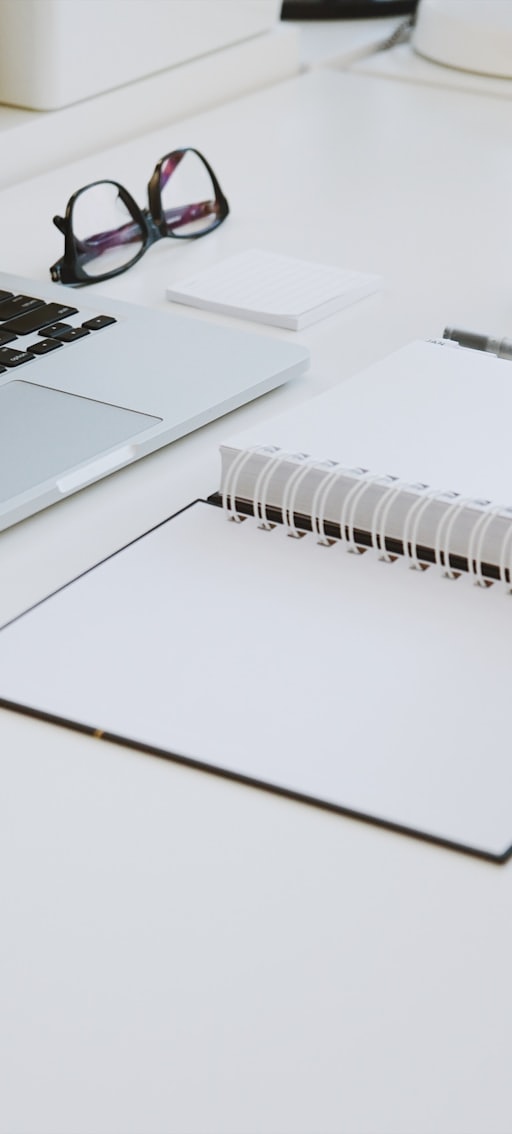 person touching white spiral notebook