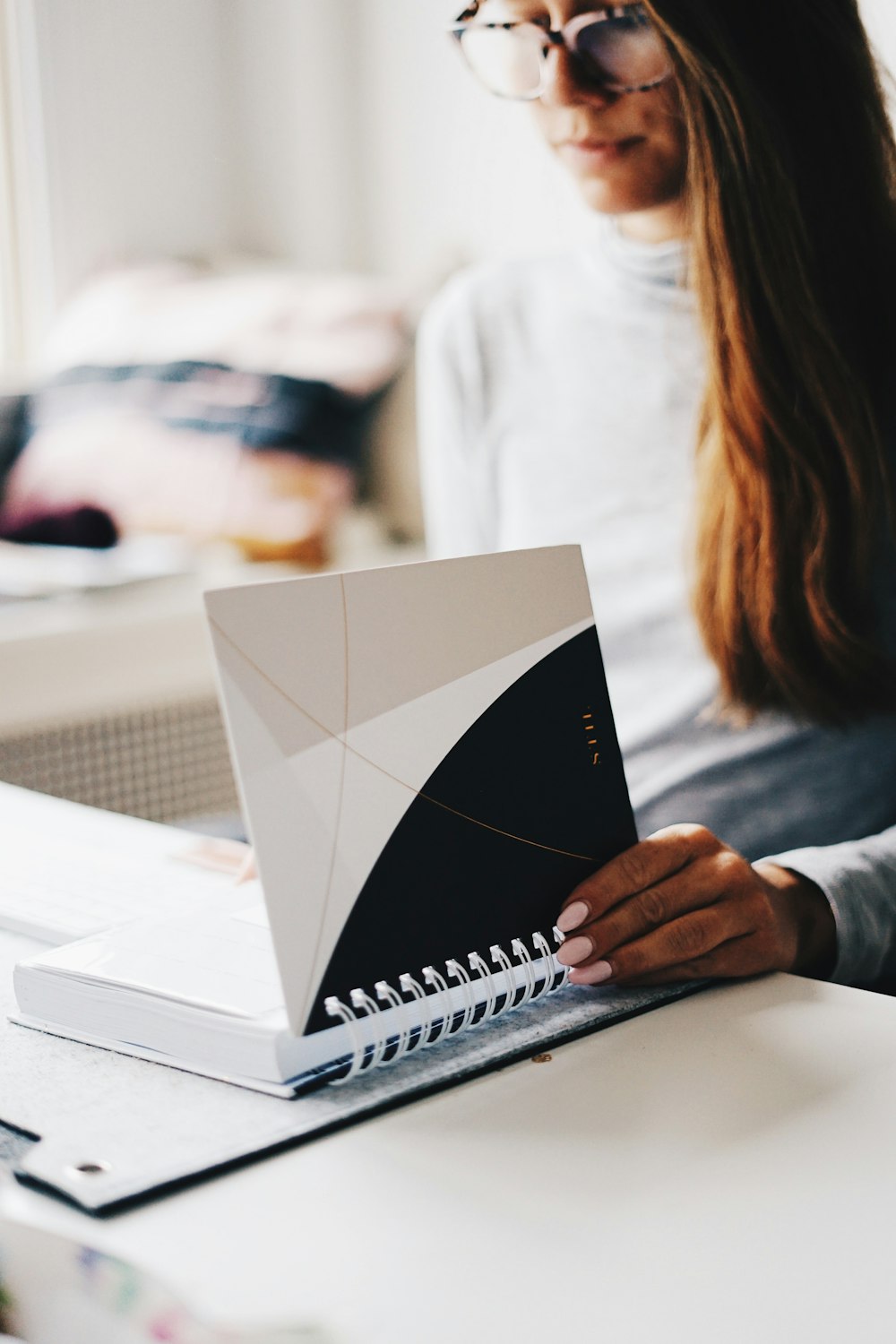 woman holding white and black notebook