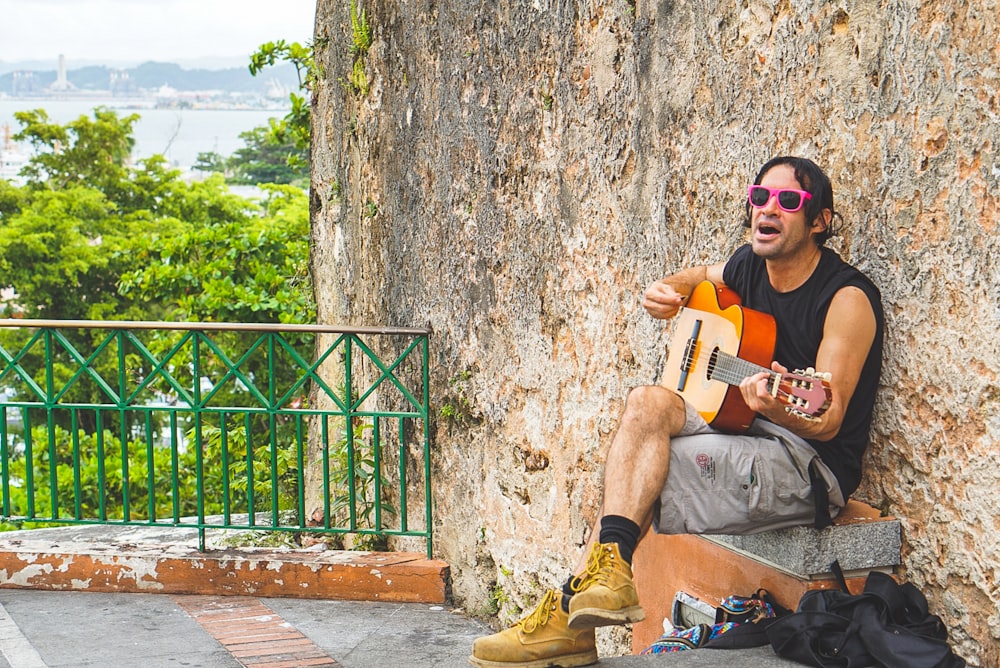 man playing guitar during daytime