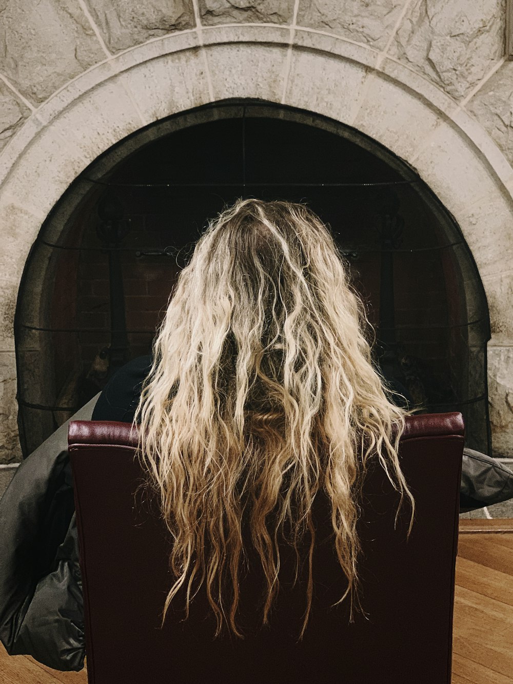 human's hair sitting on red leather sofa close-up photography