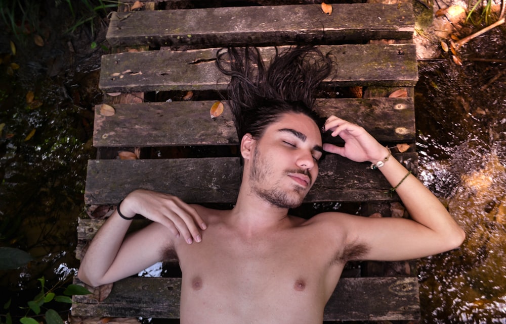 man lying on brown pallet