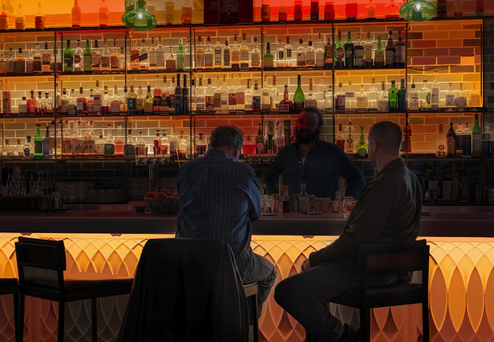 two man sitting on bar stool near table