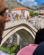 people walking on arch bridge during daytime