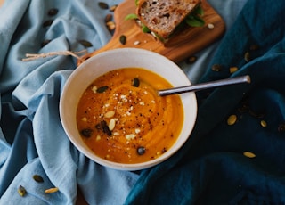 round white bowl of soup on gray textile