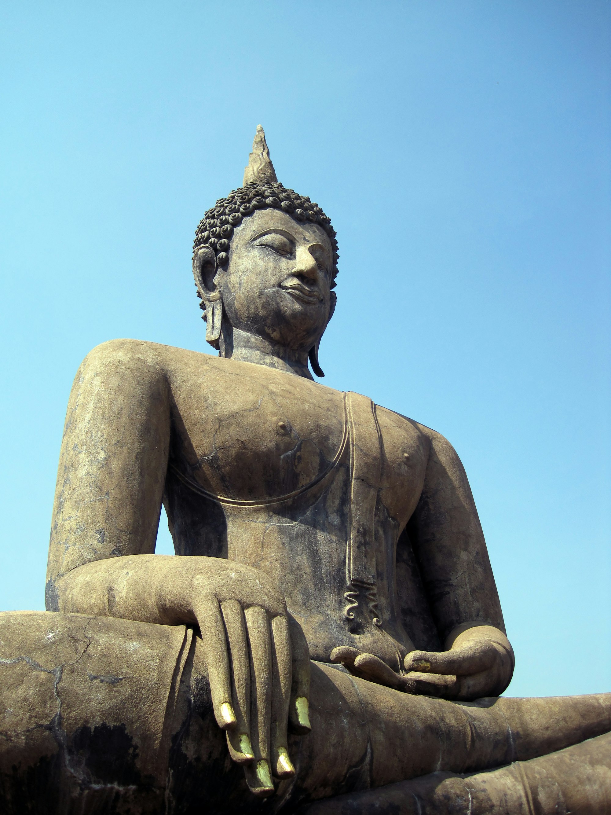 A large statue of the Buddha sitting in lotus position and showing the Bhumisparsha mudra