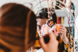 A natural shot of a college girl adjusting her hair in front of a bathroom mirror, with subtle bathroom details in the background.