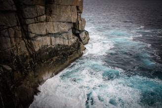 aerial view photography of waves beside seacliff