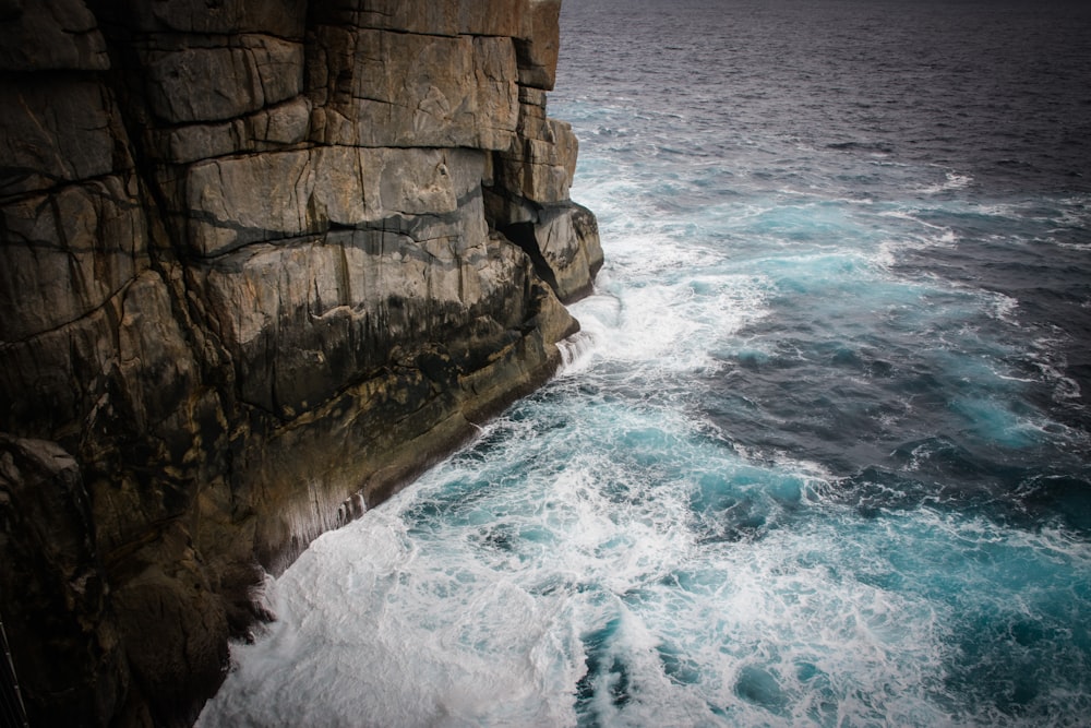 aerial view photography of waves beside seacliff