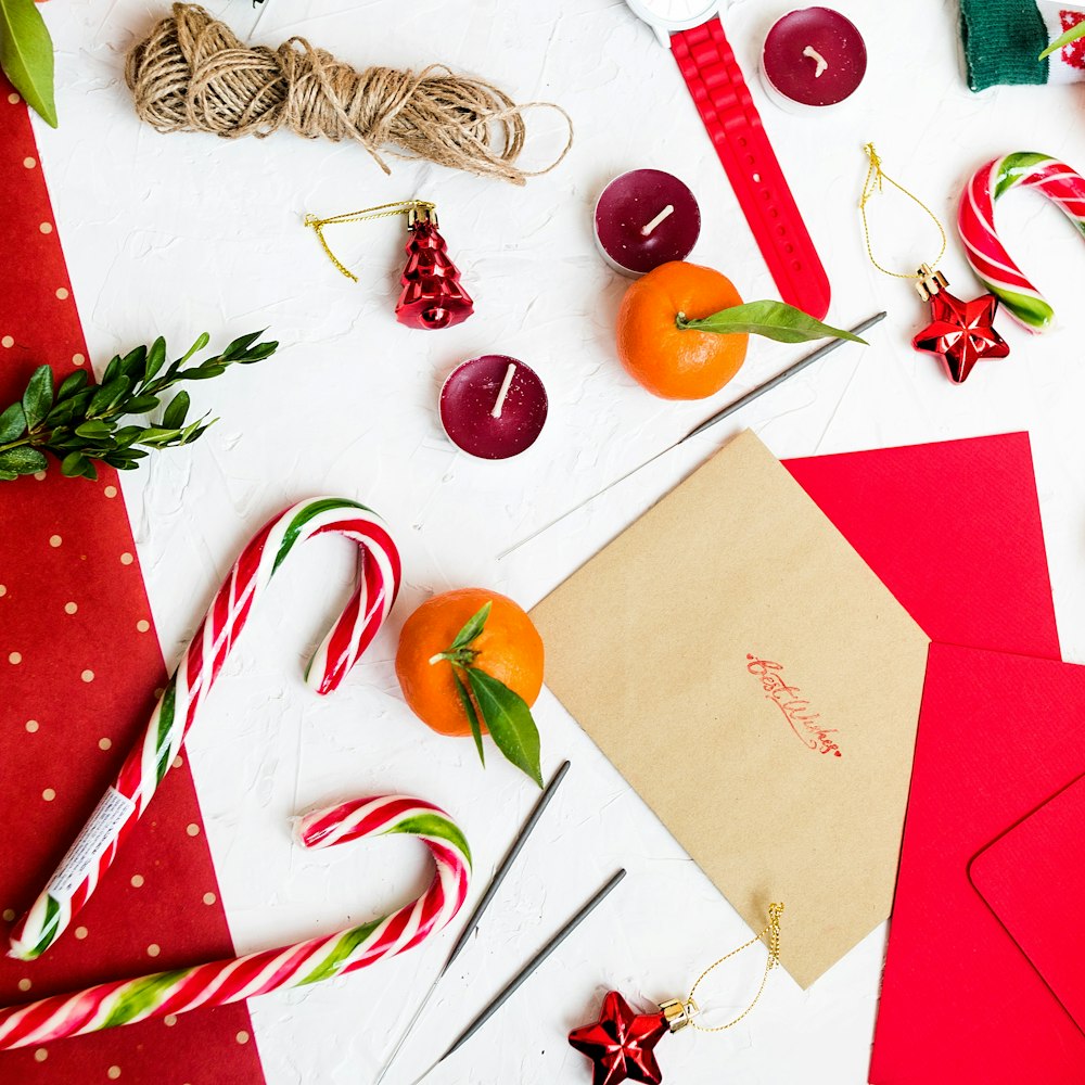 candy cane beside orange fruit and envelope paper