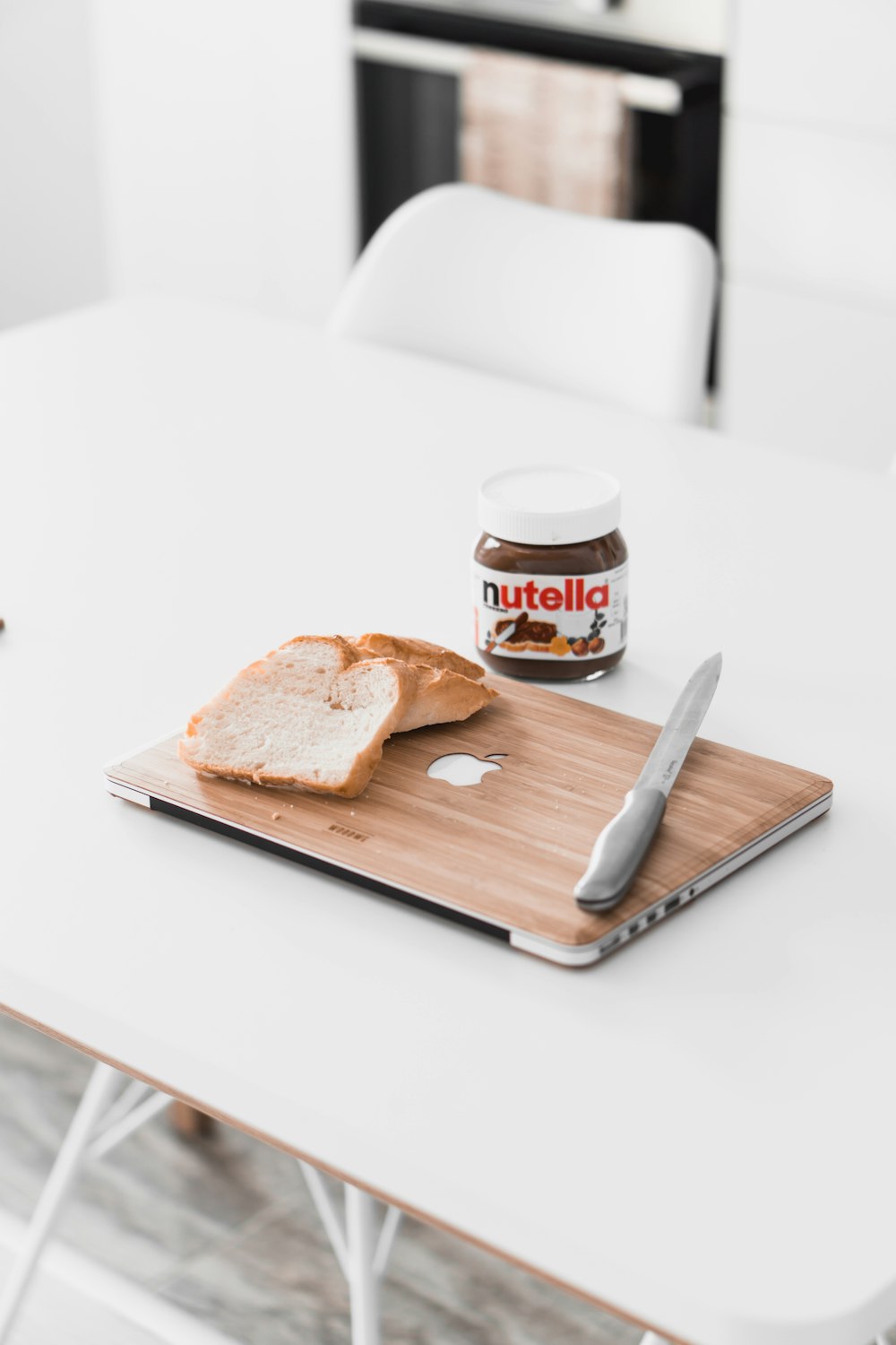sliced bread on MacBook beside Nutella chocolate bottle