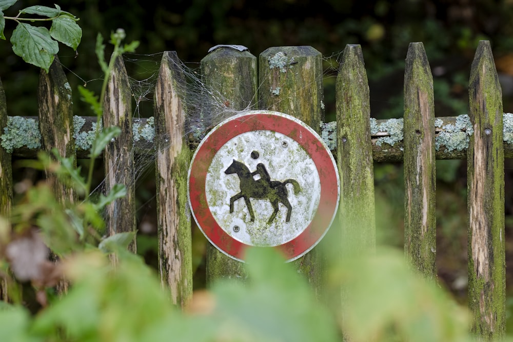 man riding horse signage on fence