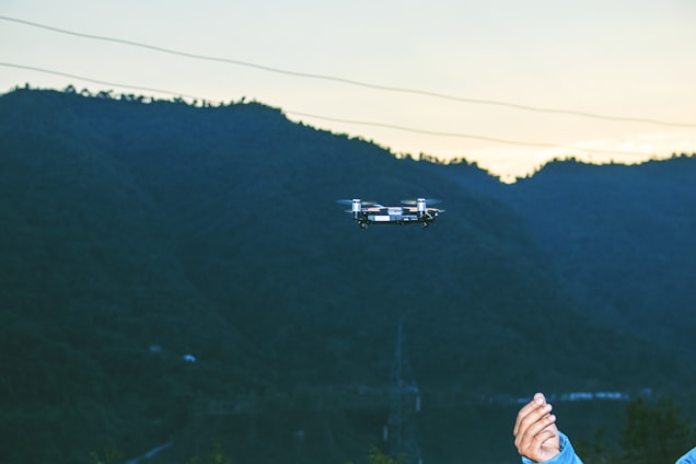 A drone flying over a serene mountain landscape during golden hour.